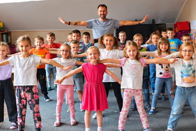 Grupa przedszkolaków powtarza ruch za instruktorem ATP Kids